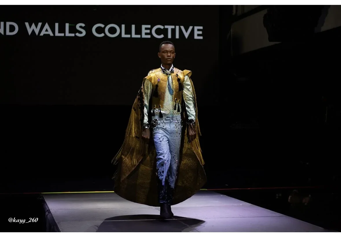 Silueta de pasarela con saco dorado y pantalón azul